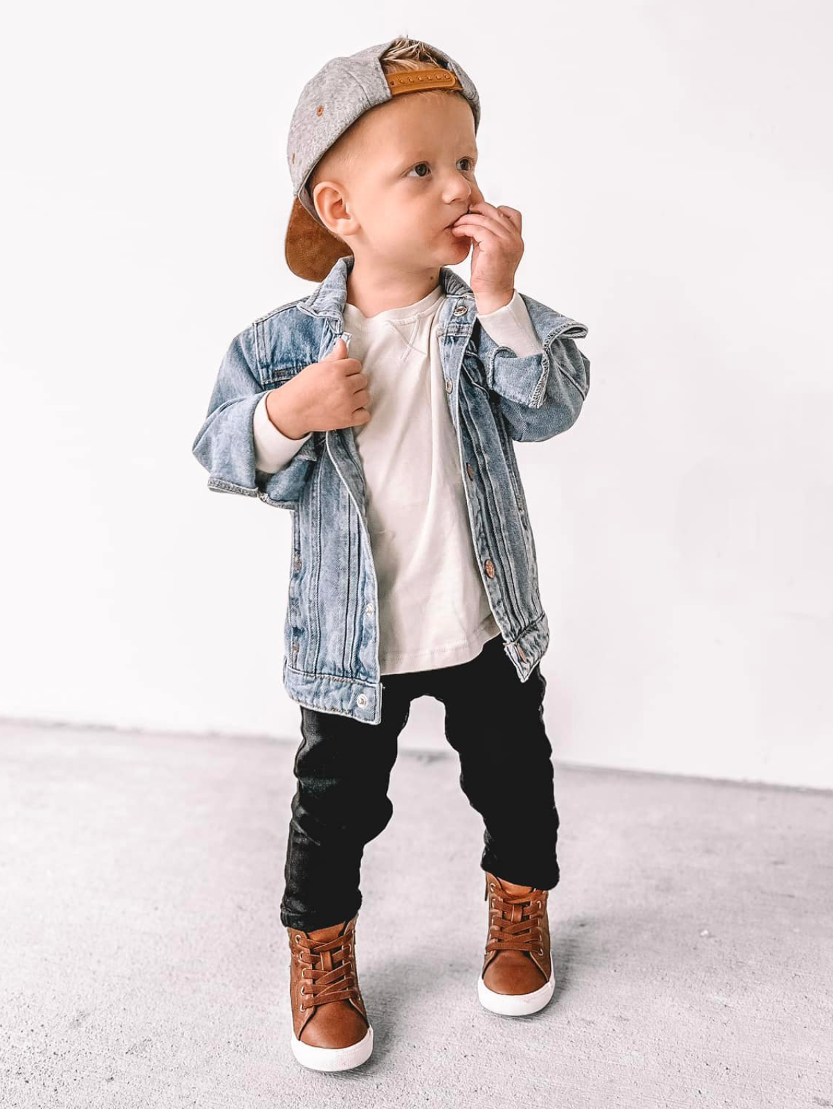 Toddler in trendy kids outfit. Kids denim jacket, kids basic long sleeve, and kids black denim.