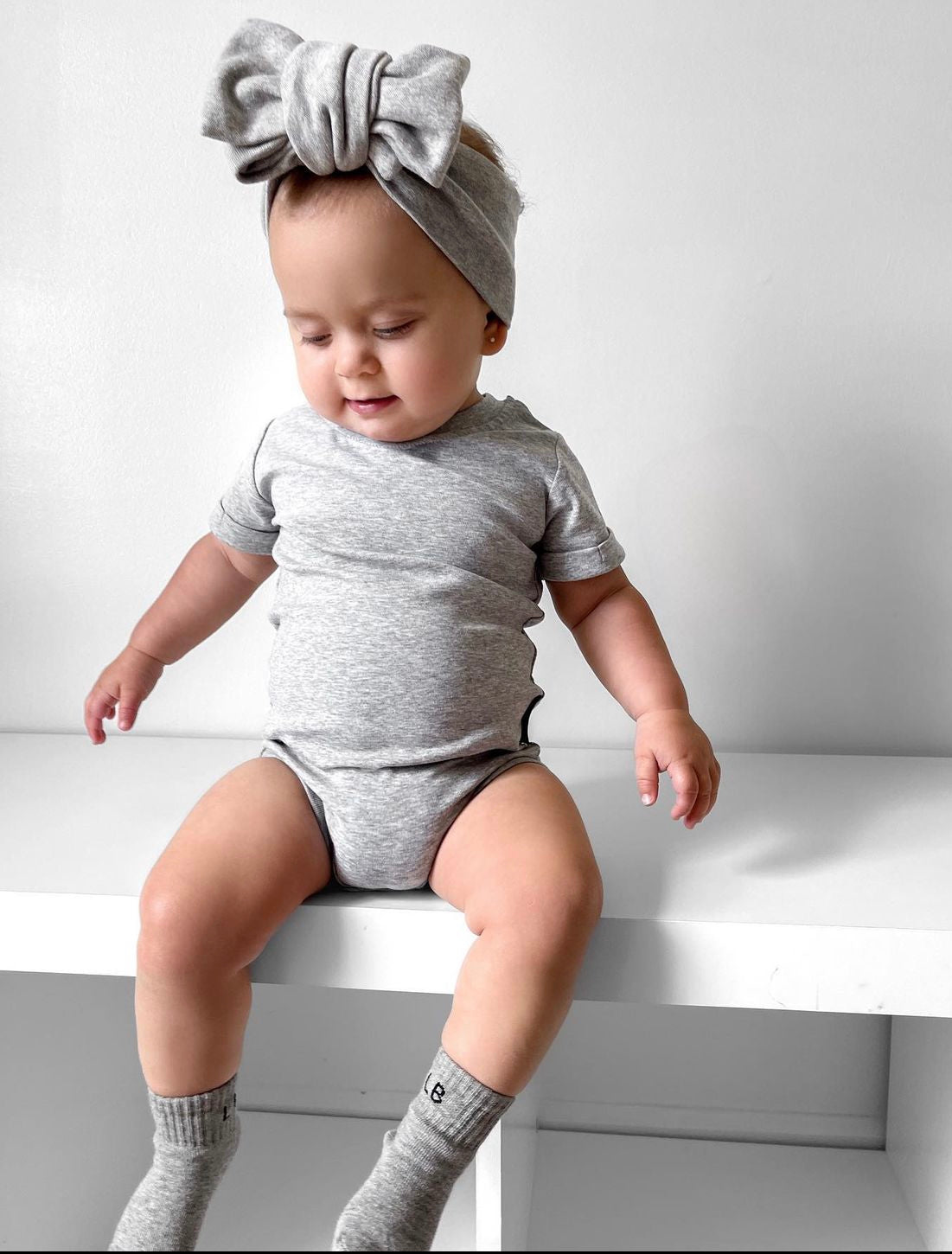 Baby in basic onesie in grey