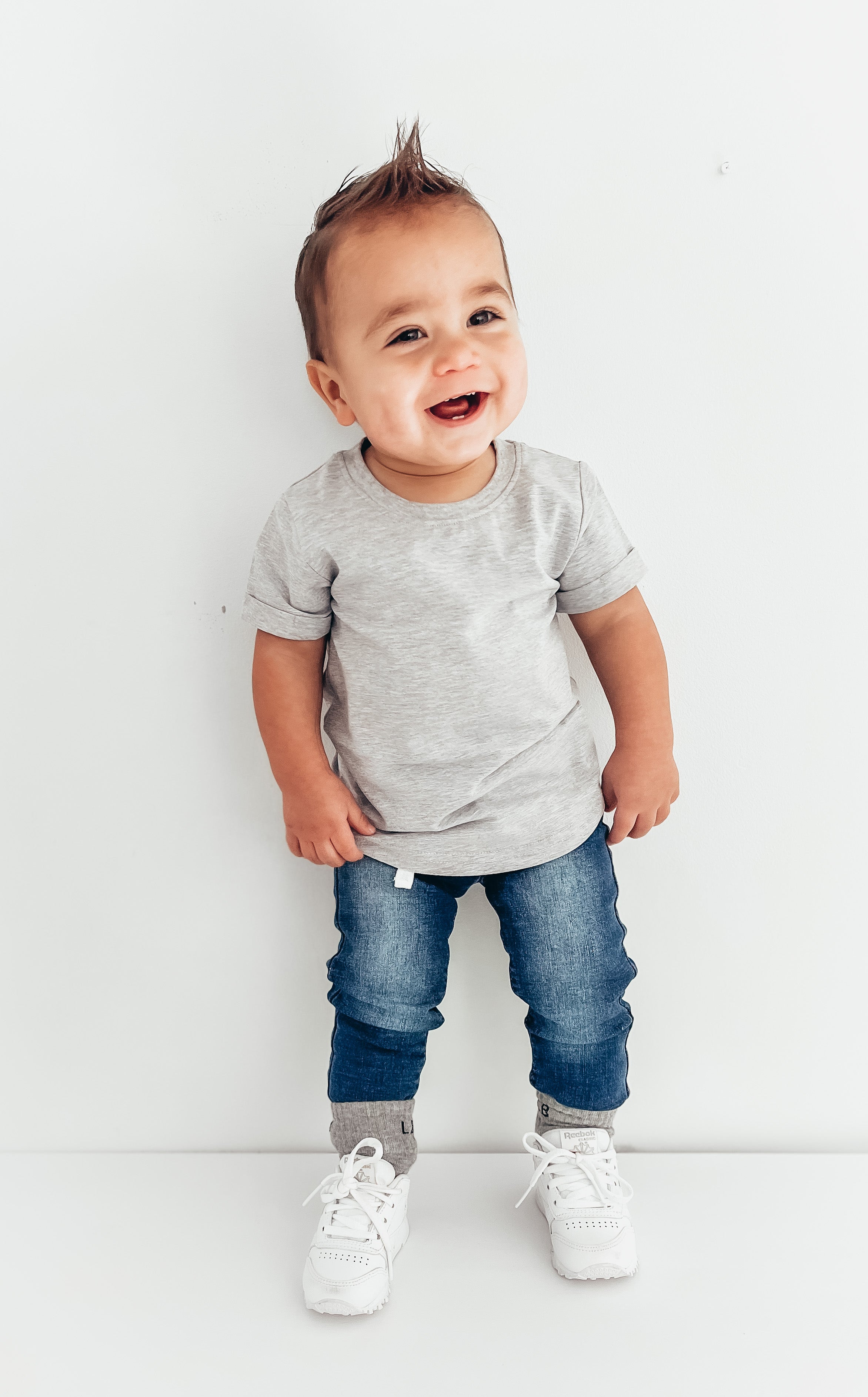 baby in baby trendy outfit with baby denim and baby socks and baby basic tee