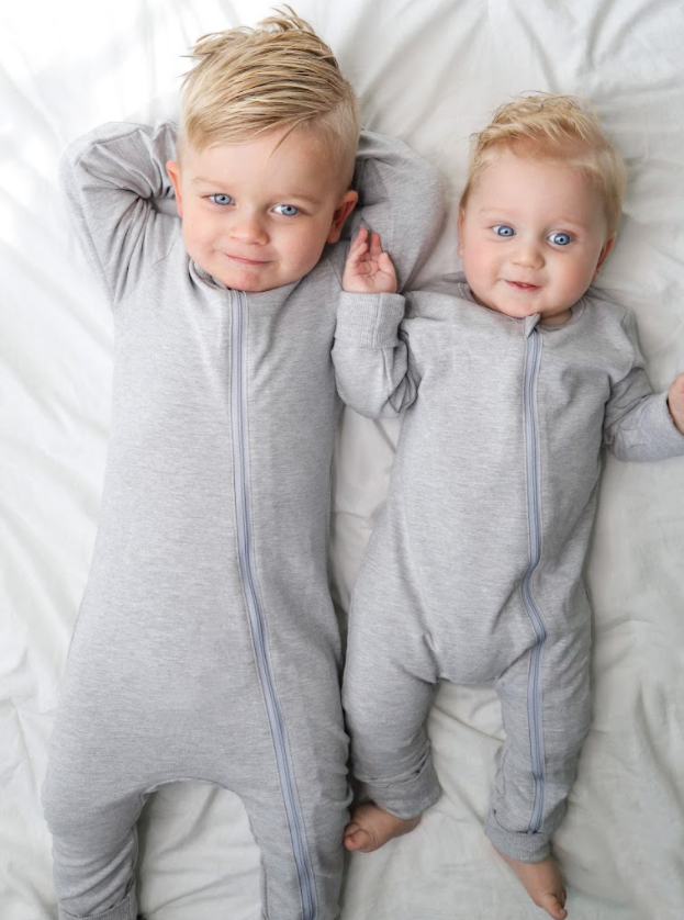 Toddler and baby siblings in matching grey onesies