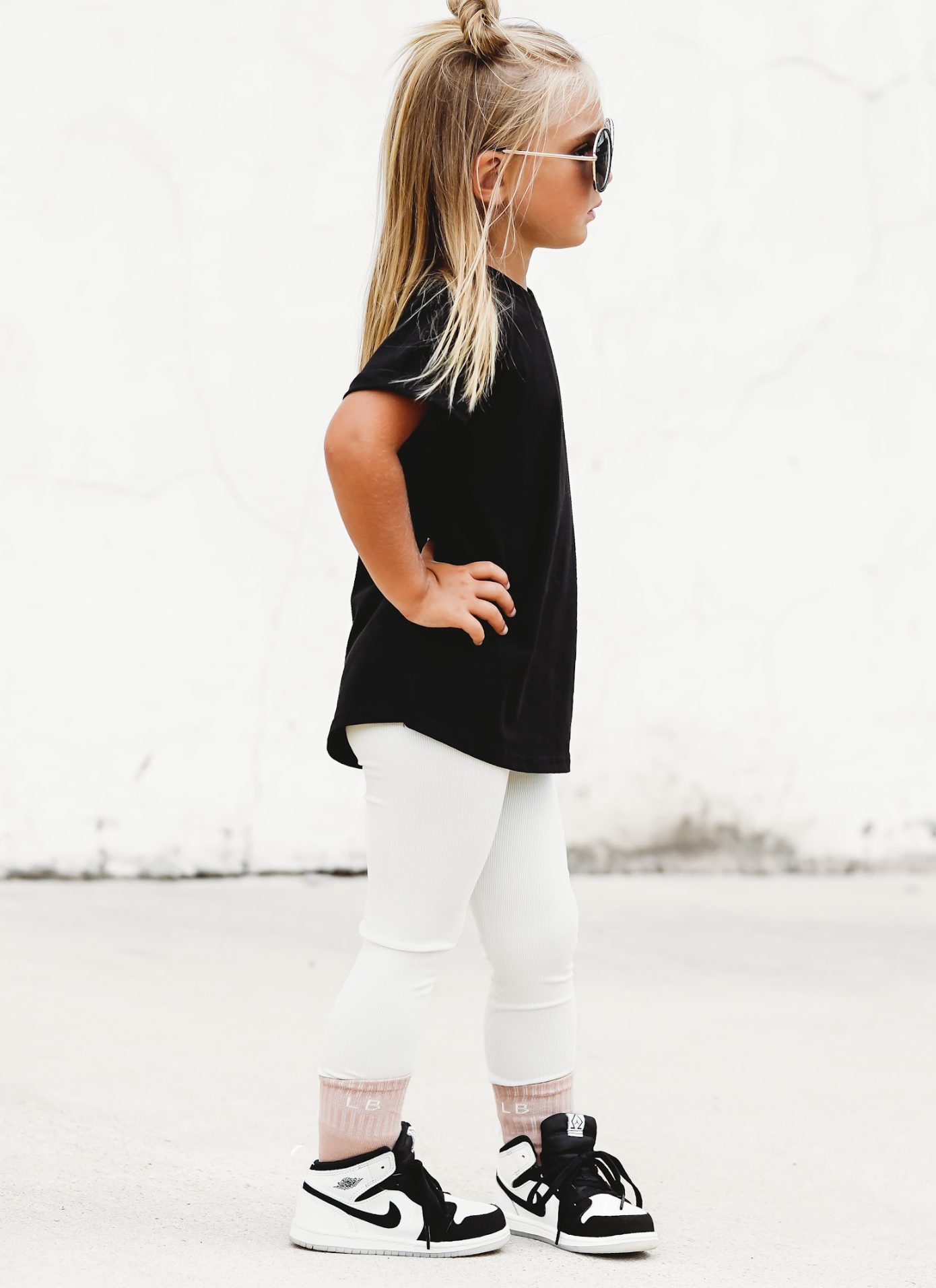 Little girl in kids trendy outfit. Basic black tee and kids leggings